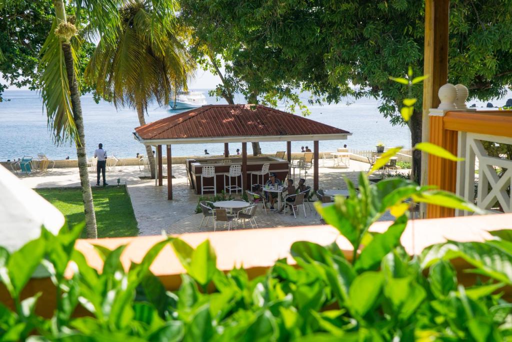 a gazebo on the beach with people sitting in it at Sunset Shores Beach Hotel in Kingstown