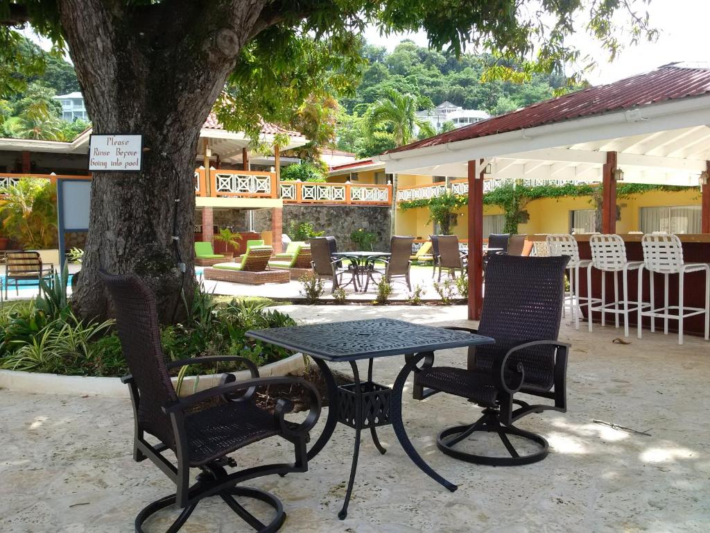 a table and chairs sitting under a tree at Sunset Shores Beach Hotel in Kingstown