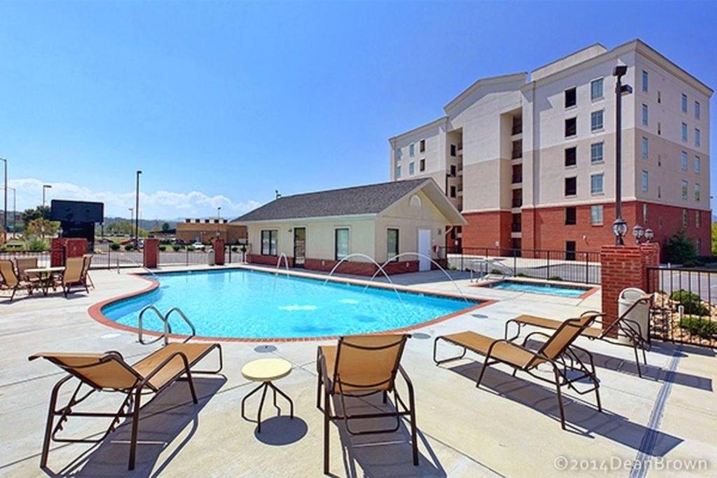 uma piscina com cadeiras e um edifício em River Crossing #405 em Pigeon Forge