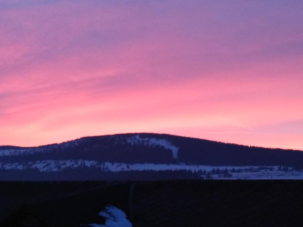a sunset over a mountain with snow and trees at Apartmány Grobarčík in Zuberec