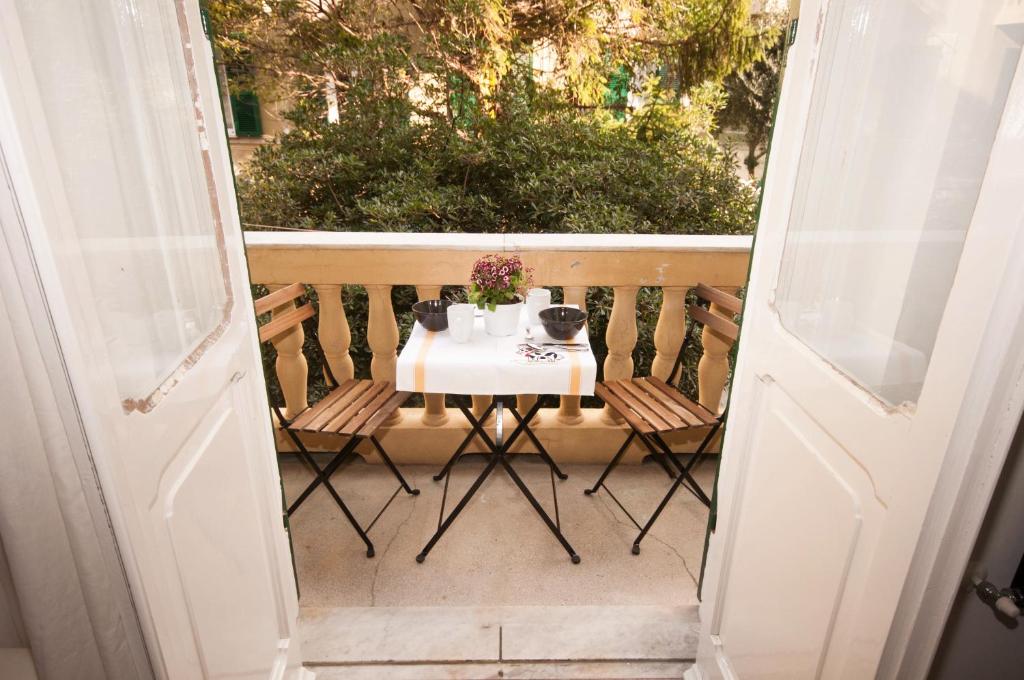 uma porta aberta com uma mesa e cadeiras numa varanda em Perdiana House em Génova