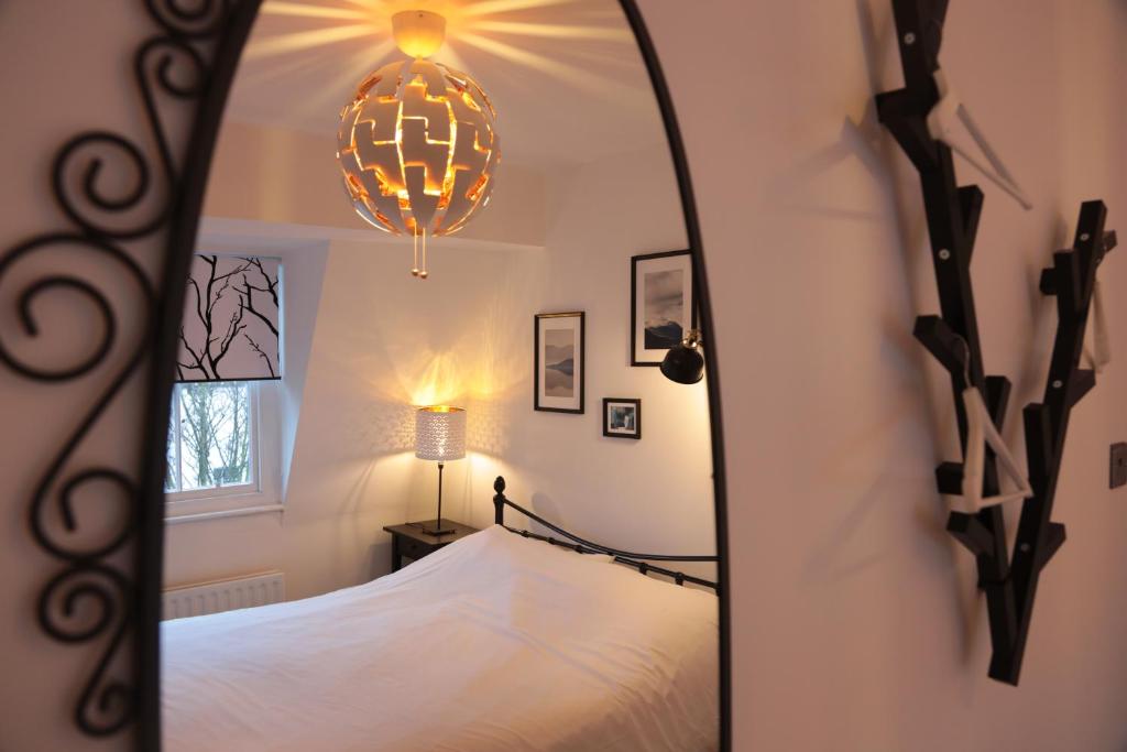 um espelho num quarto com uma cama e um candeeiro em Kings Cross Apartments em Londres