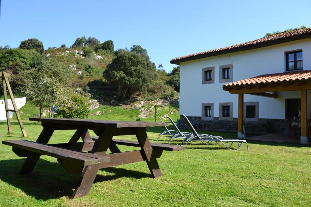 a picnic table in the grass in front of a house at El Molin De Frieras in Posada de Llanes