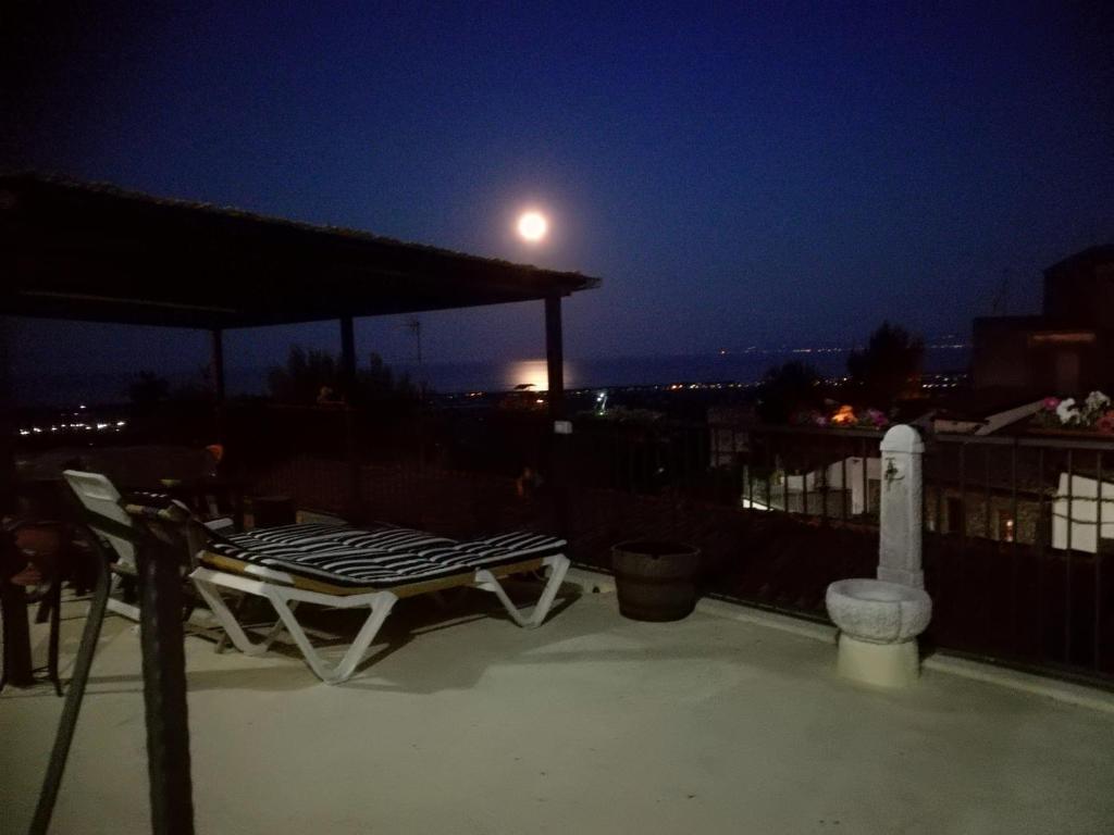 una sedia da patio e un tavolo all'ultimo piano di notte di La Panoramica a Villapiana