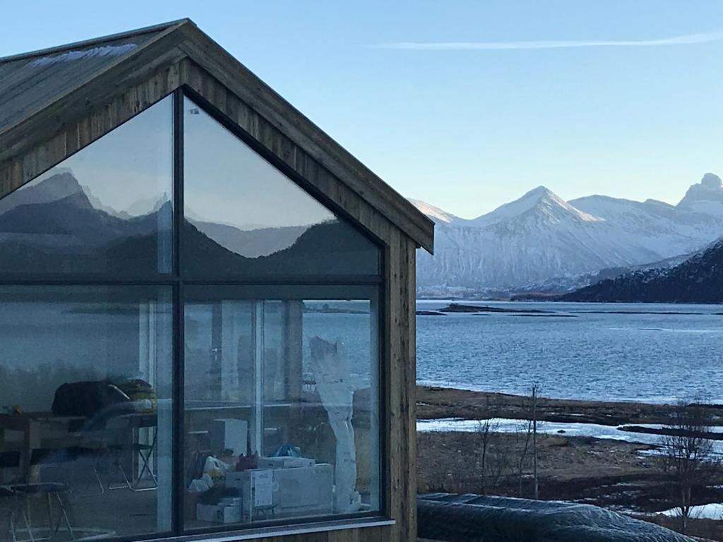 a house with a cat reflection in the window at Steigen Lodge Sjøhytter in Engeløya