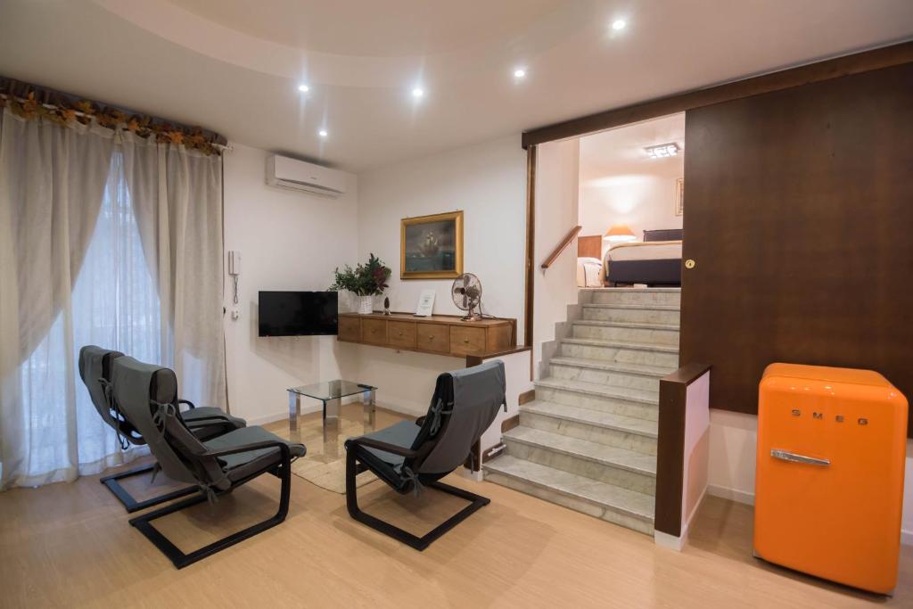 ナポリにあるLa Residenza Napoli Chiaia short let Apartment Superior Via Chiaia 82の椅子2脚と階段(ベッド1台付)が備わる客室です。
