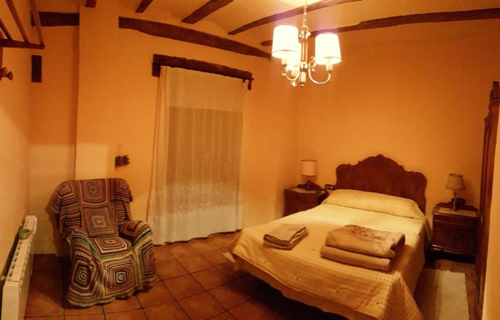 a bedroom with a bed and a chair in it at Casa Francisco Teruel in Cascante del Río