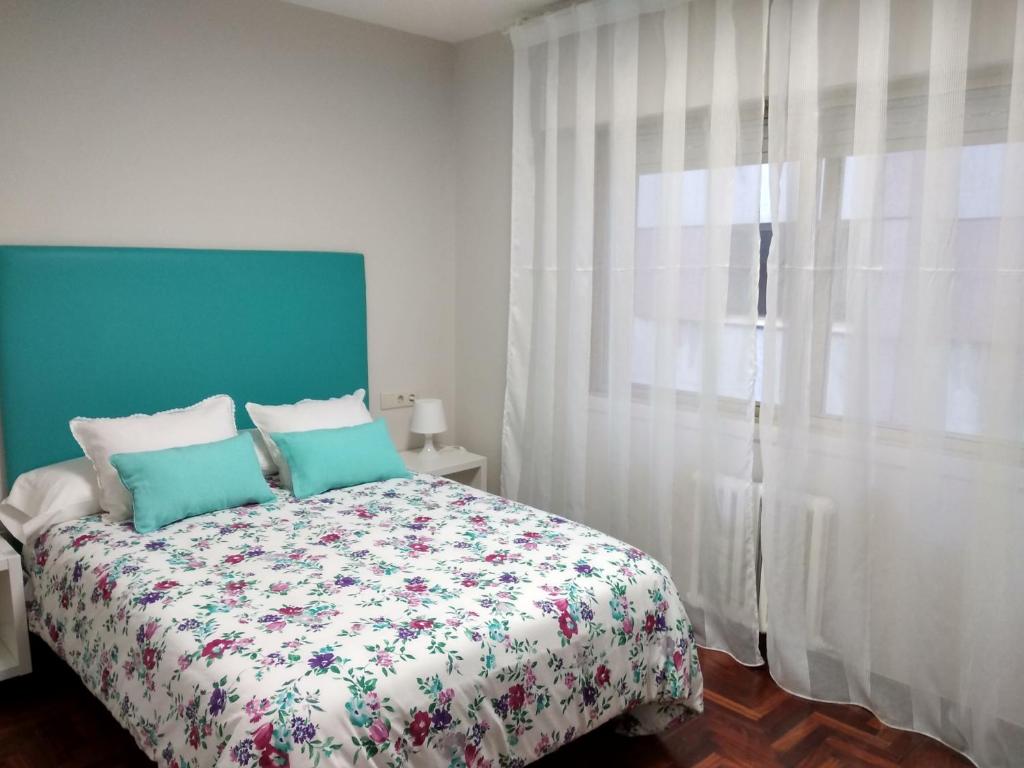 1 dormitorio con 1 cama y una ventana con cortinas blancas en En el Corazón de Pontevedra, en Pontevedra