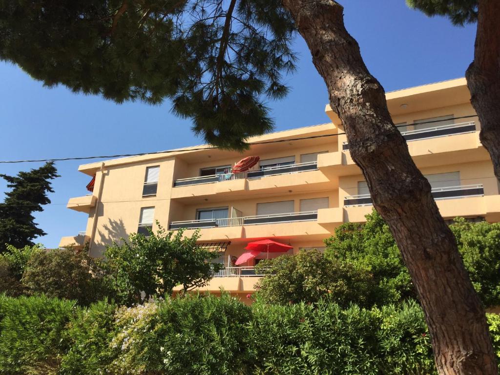 un bâtiment avec un parapluie rouge devant lui dans l'établissement studio avec terrasse parking, à Six-Fours-les-Plages