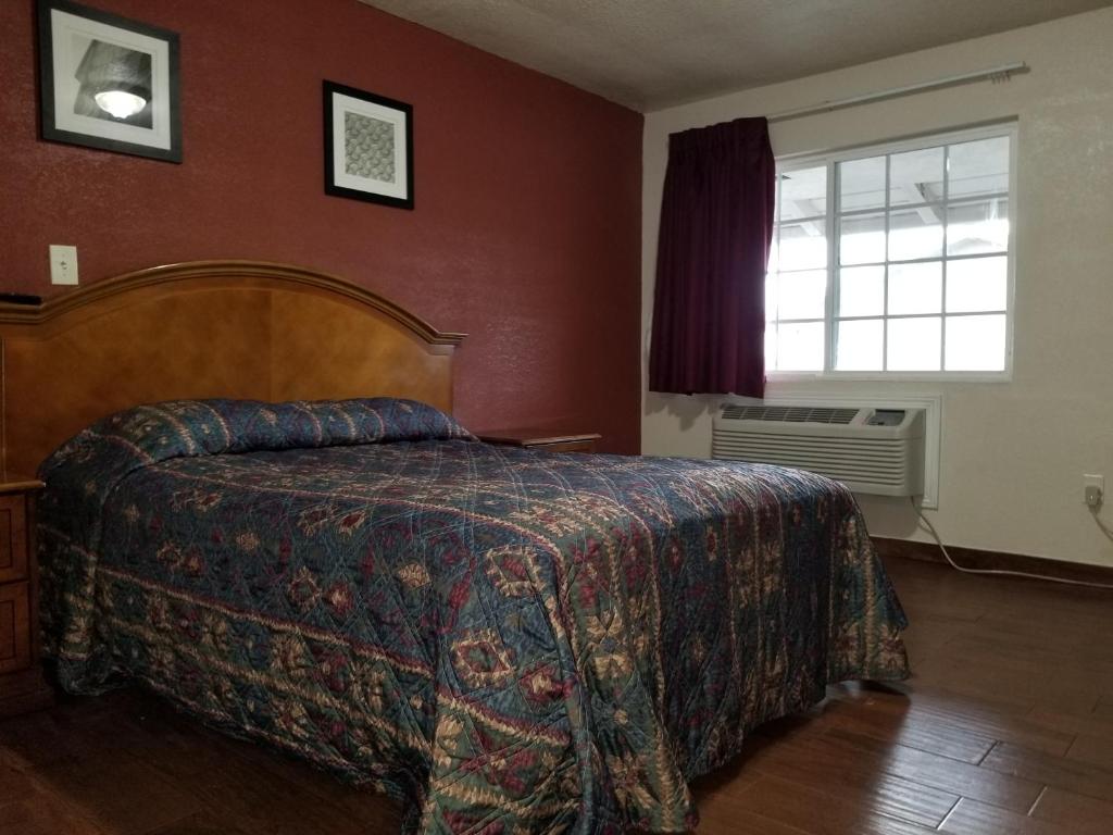 a bedroom with a bed and a window at Buckboard Motel in Santa Maria