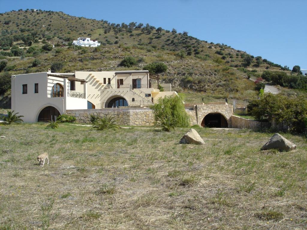 una casa en la cima de una colina con una montaña en Island Villa en Agia Galini