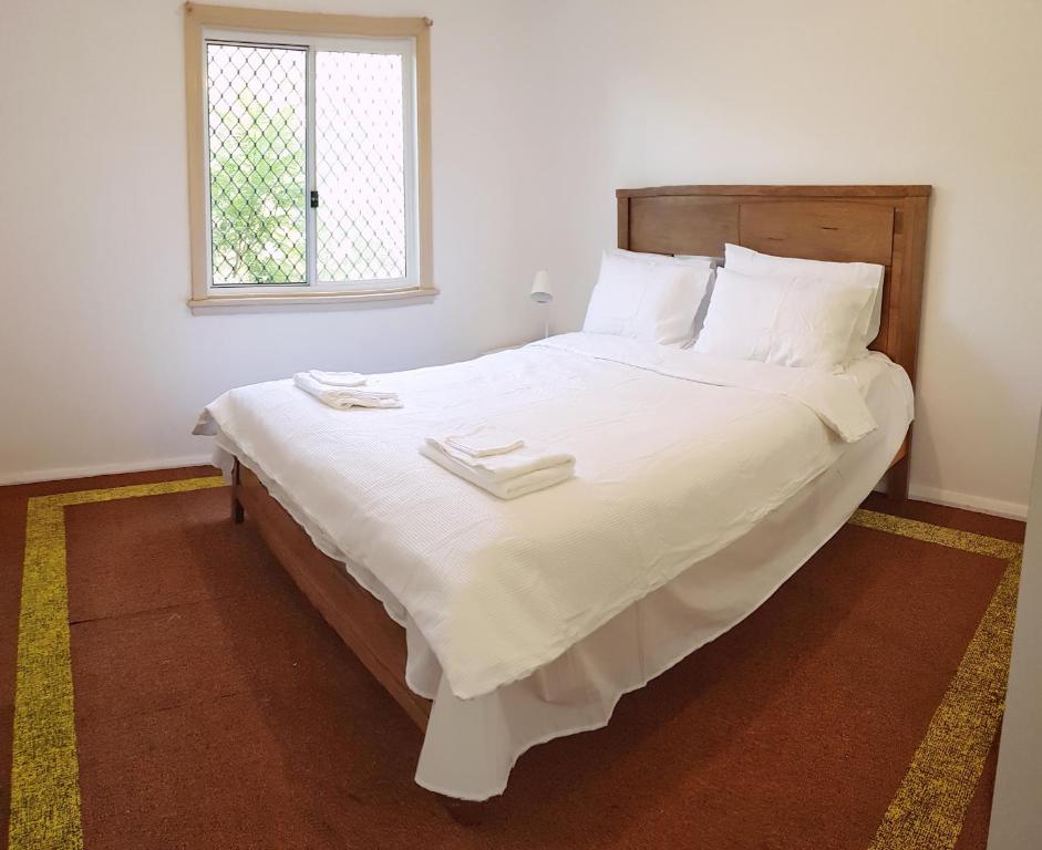 1 cama blanca grande en una habitación con ventana en Lowest Price Clean Linen free stuff free car parking inside property W1, en Wentworthville