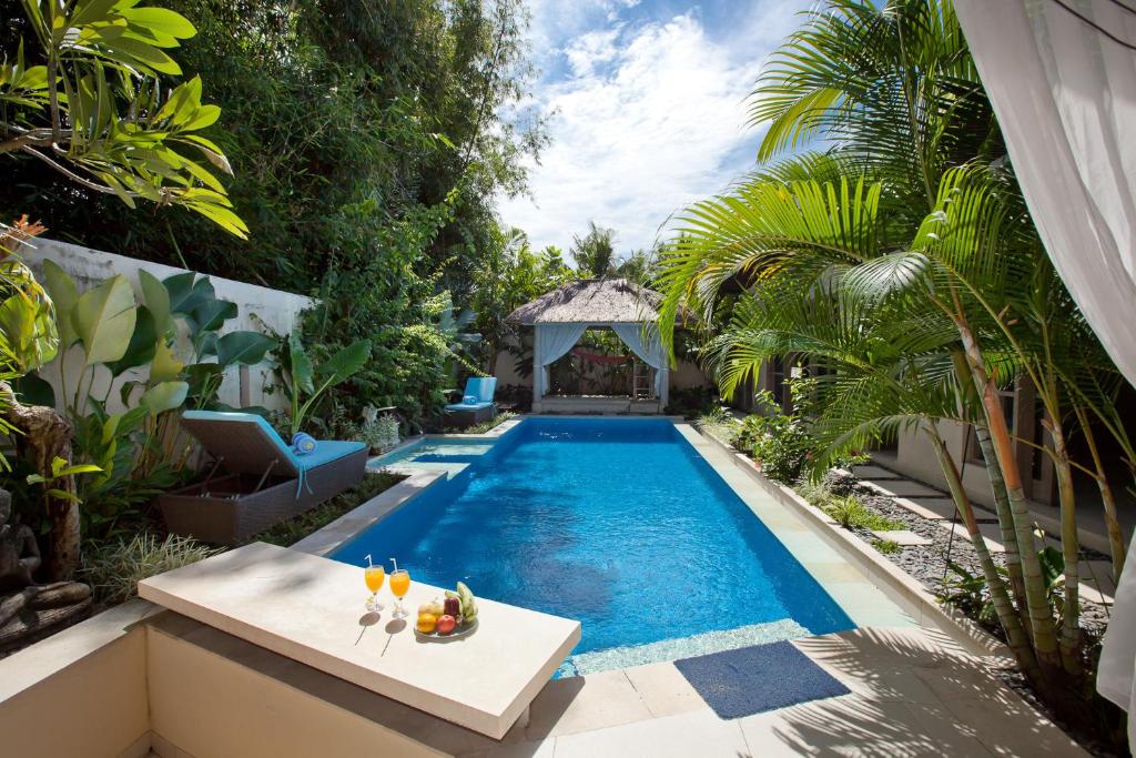 a swimming pool with a table with fruit on it at Enigma Bali Villas in Canggu