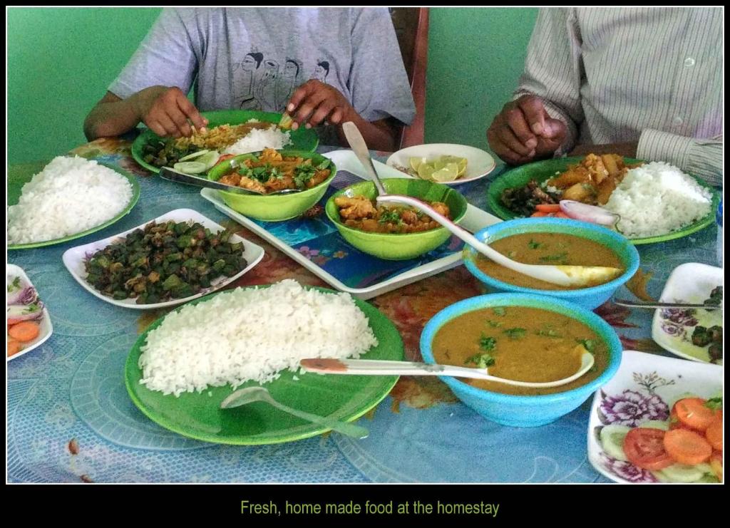 a table topped with plates of food and bowls of rice at The Lagoon shade in Port Blair