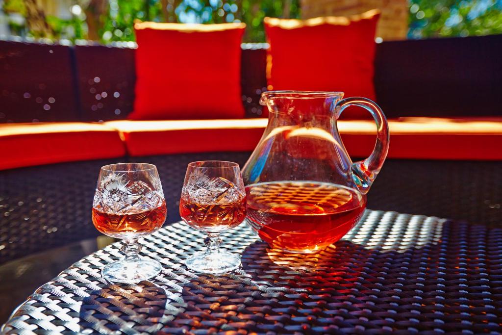 three wine glasses and a jug on a table at Anemelia' Villa in Áyios Dhimítrios