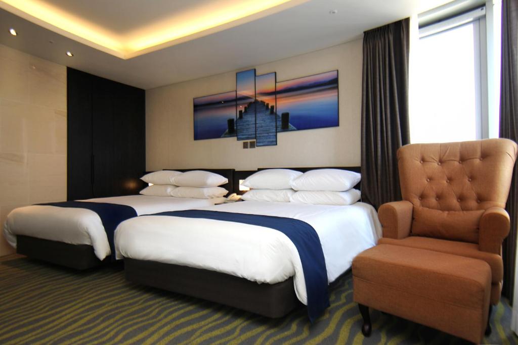 Postel nebo postele na pokoji v ubytování Gloucester Hotel Jeju