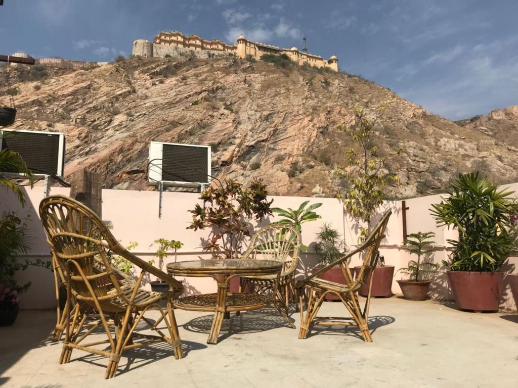 une table et des chaises avec un château sur une colline dans l'établissement Nahargarh Palace Hotel, à Jaipur