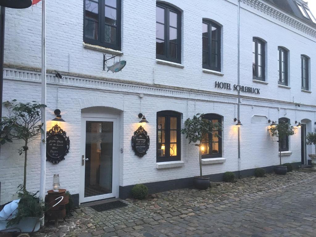 a white building with a row of windows on a street at Das Kleine Hotel Schleiblick in Schleswig