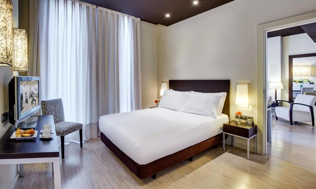 1 dormitorio con 1 cama y sala de estar en Sercotel Boulevard Vitoria-Gasteiz, en Vitoria-Gasteiz