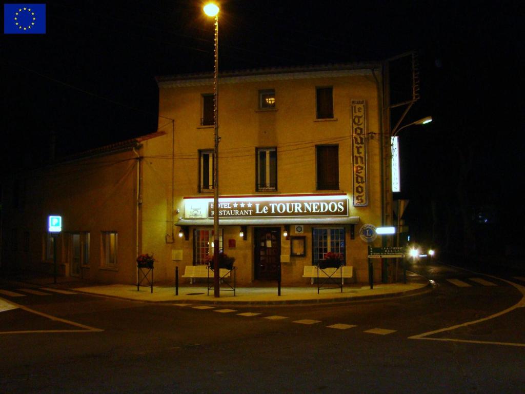 un edificio con una señal para un teatro por la noche en Le Tournedos, en Lézignan-Corbières