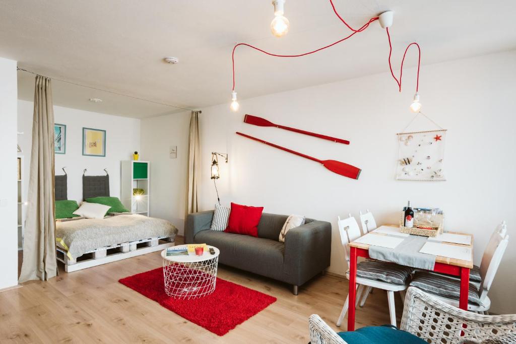 a living room with a couch and a table at MOOKI Beach Apartment in Bodensdorf