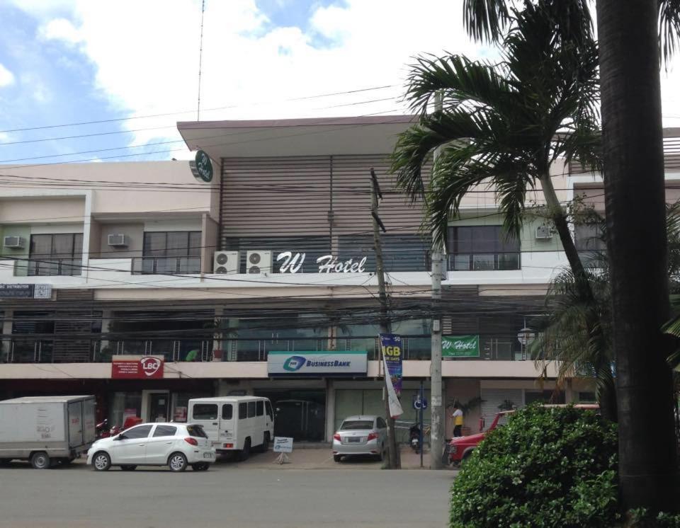 ein Gebäude mit Autos auf einem Parkplatz in der Unterkunft W Hotel in Zamboanga