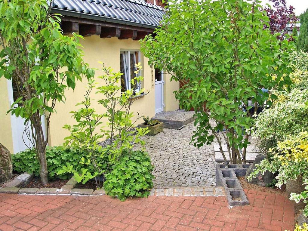 ヴァーレンにあるFerienhaus mit separater Wohnung Waren SEE 9441のレンガ造りの庭前の木々のある家