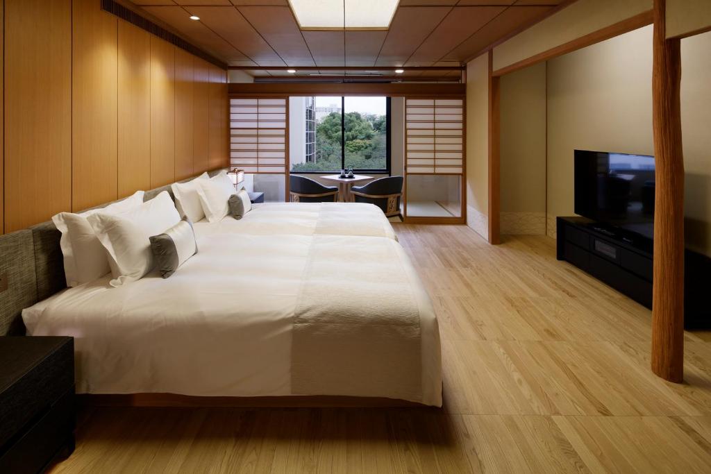 東京にあるTakanawa Hanakohro - in Grand Prince Hotel Takanawaのベッドルーム(大きな白いベッド1台、テレビ付)