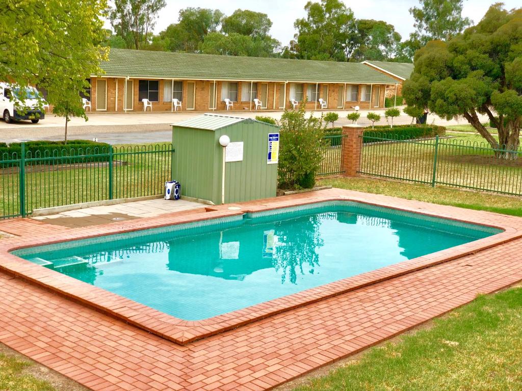 a swimming pool in a yard next to a fence at Golfview Motor Inn in Wagga Wagga