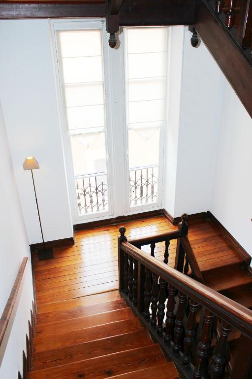 a staircase in a building with two large windows at Hôtel & Espace Bien-être La Maison du Lierre in Biarritz