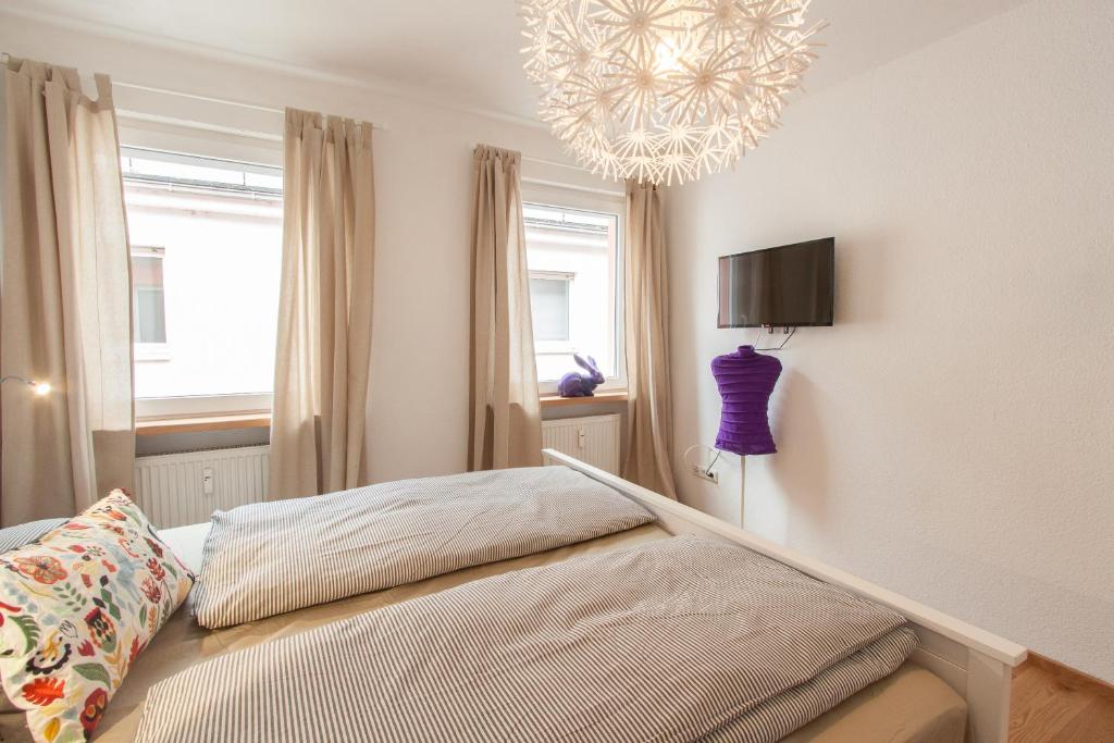 a bedroom with a bed and a chandelier at Wohnen an der Juliuspromenade Stadt in Würzburg