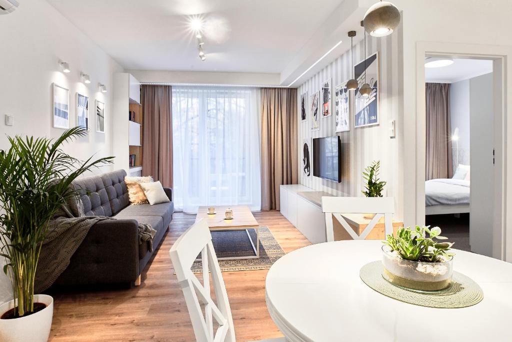 een woonkamer met een bank en een tafel bij Mojito Apartments - Botanica II in Wrocław