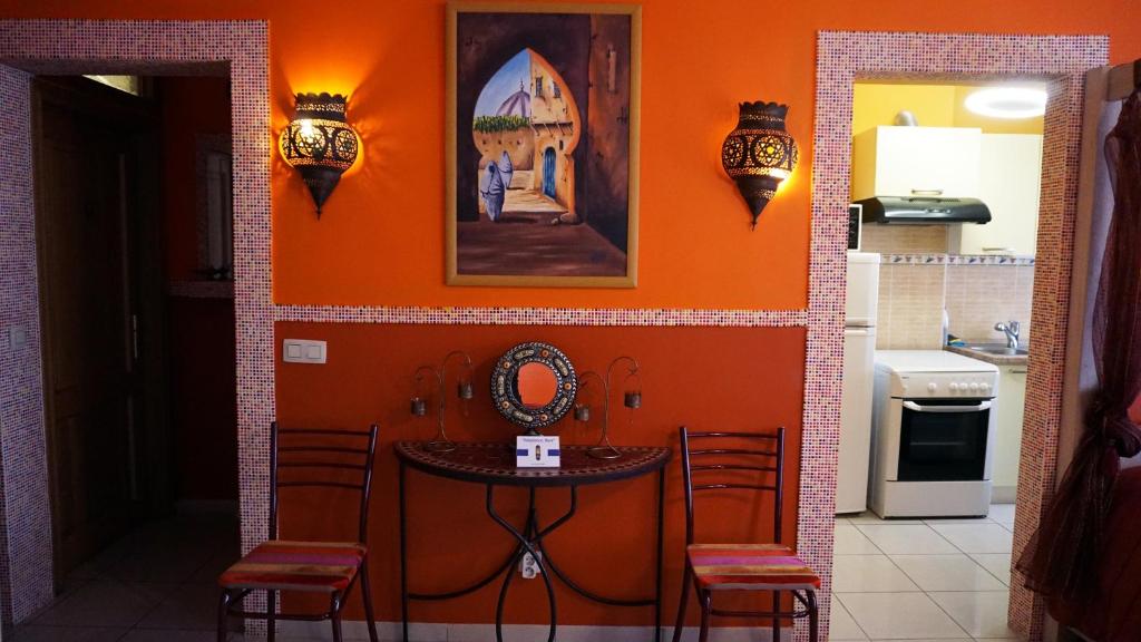 a kitchen with an orange wall with a table and chairs at Aparthotel Résidence Bara Midi in Brussels