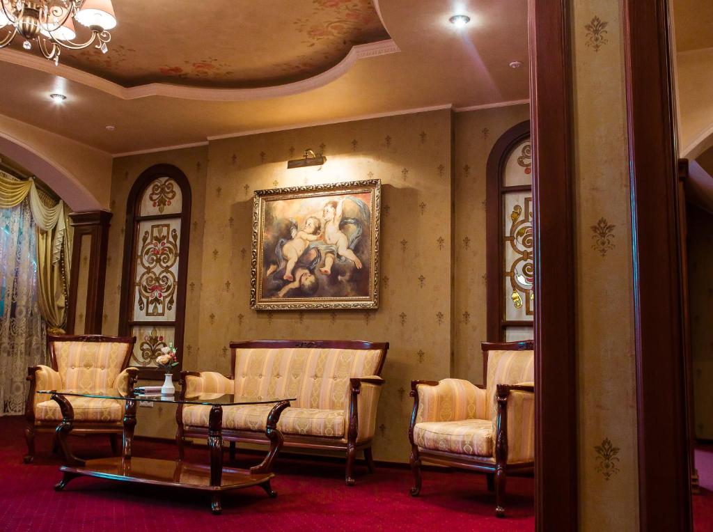 ウージュホロドにあるHotel Elefantの椅子と壁画のある部屋