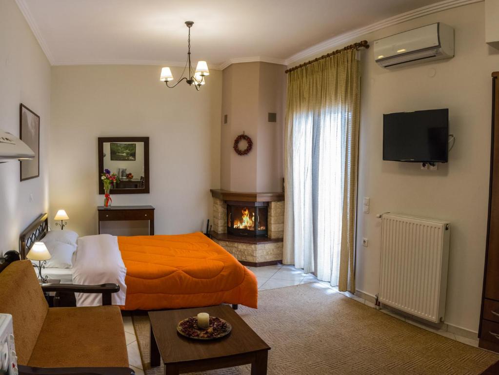 - une chambre avec un lit orange et une cheminée dans l'établissement Chrysandra, à Karpenísi