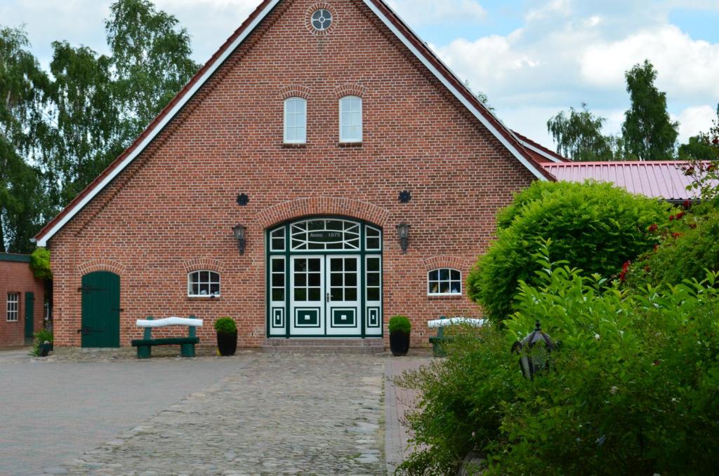 un grand bâtiment en briques rouges avec une grande porte dans l'établissement Ferienhof Blunck, à Wangels