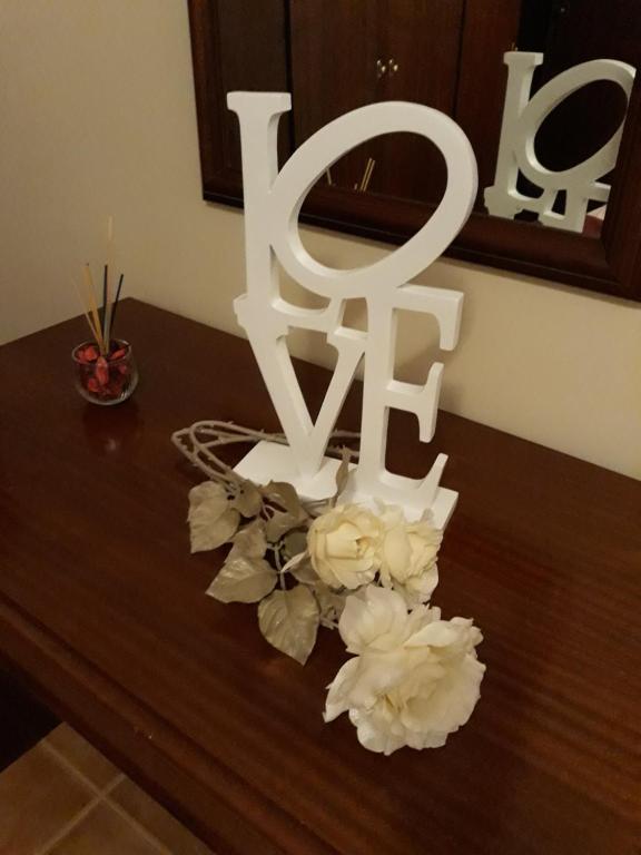 einen Tisch mit weißen Blumen und einem weißen Schild in der Unterkunft Apartamento Arrifes in Porto Santo