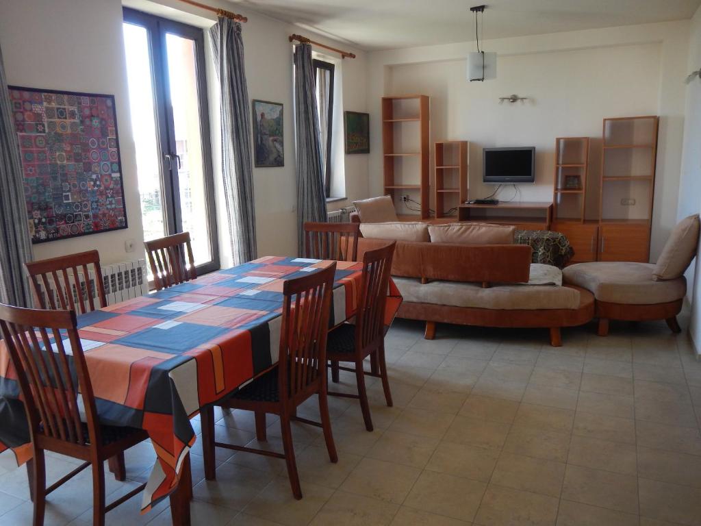 Spacious apartment in Aygedzor street في يريفان: غرفة معيشة مع طاولة وكراسي وأريكة