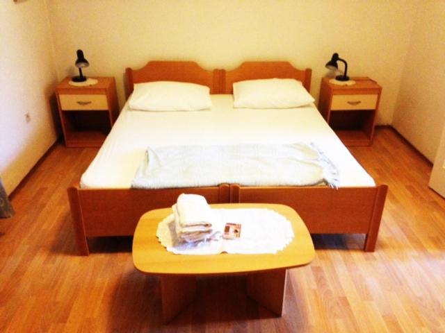 1 dormitorio con 1 cama con 2 mesitas de noche y mesa en Apartman Gracin en Primošten