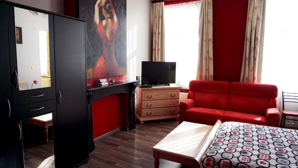 a living room with a bed and a red couch at Apartments Marco Polo Midi in Brussels