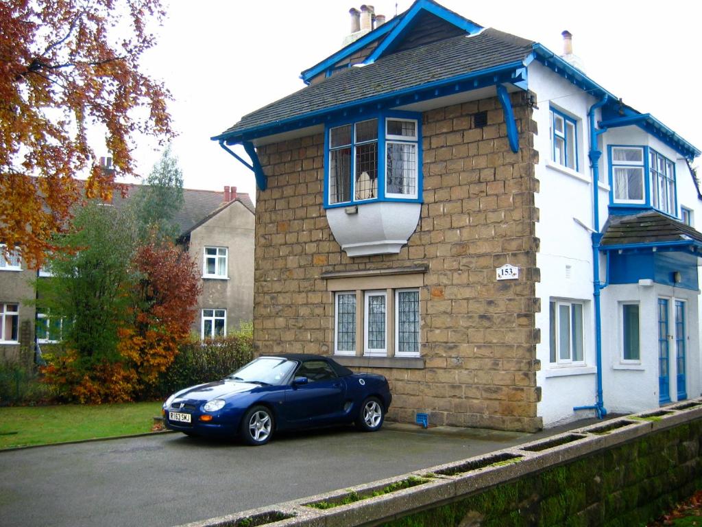 里茲的住宿－The Tops Self Catering，停在房子前面的蓝色汽车