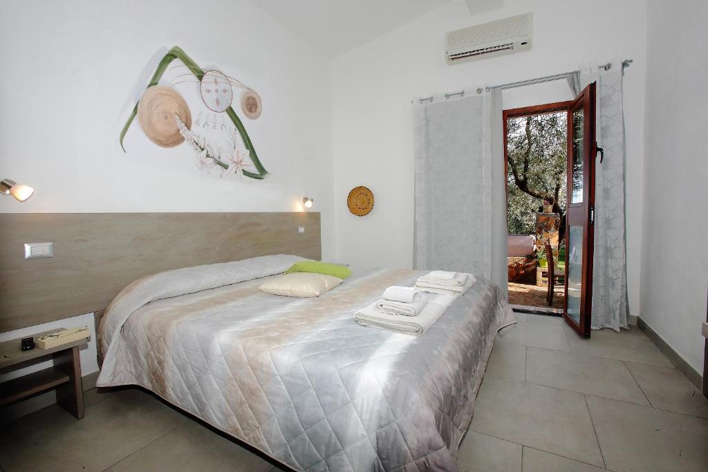 - une chambre avec un lit et des serviettes dans l'établissement B&B Campu Moru, à Bari Sardo