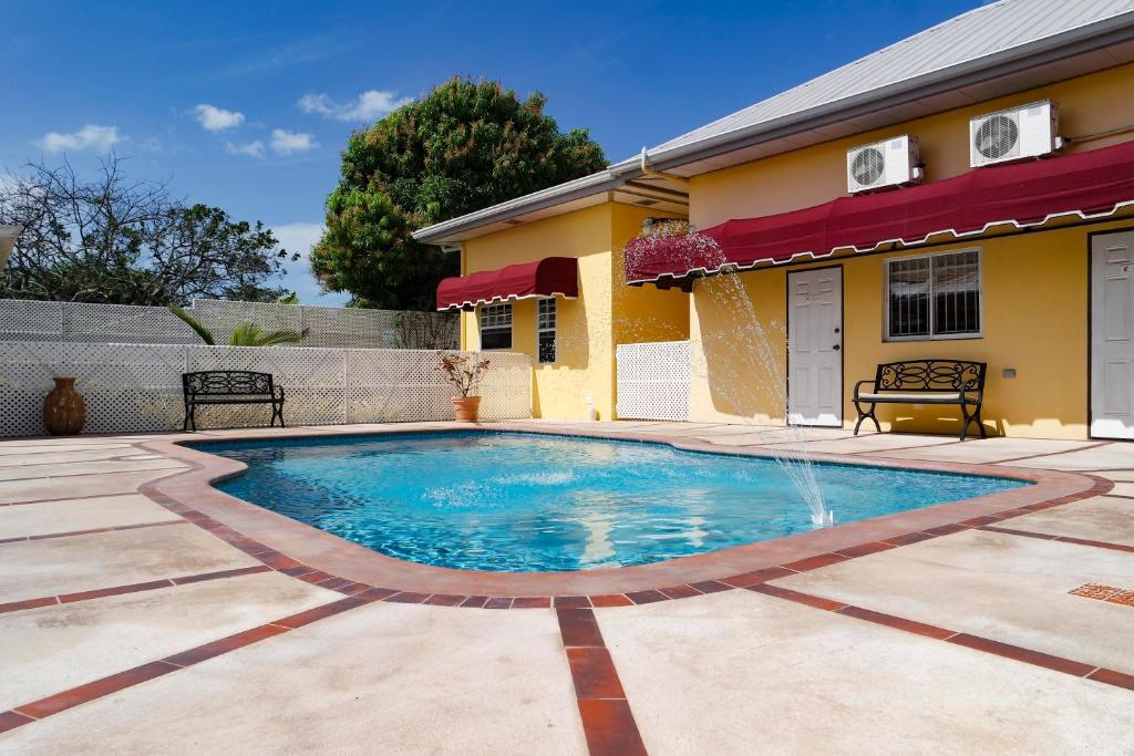 a swimming pool in front of a house at Kiskadee Korner in Port-of-Spain