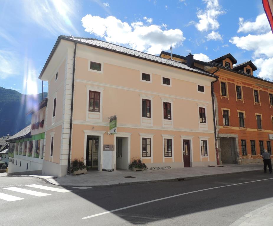 ein großes weißes Gebäude an der Straßenseite in der Unterkunft Apartma Bovec in Bovec