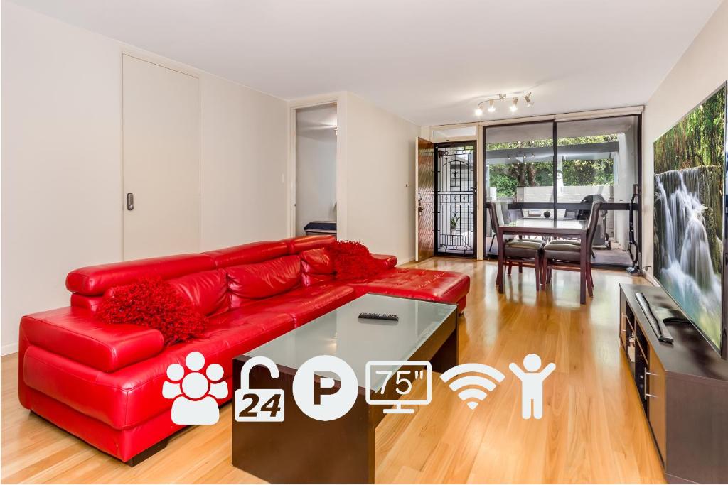 a living room with a red couch and a tv at City Gardens in Perth