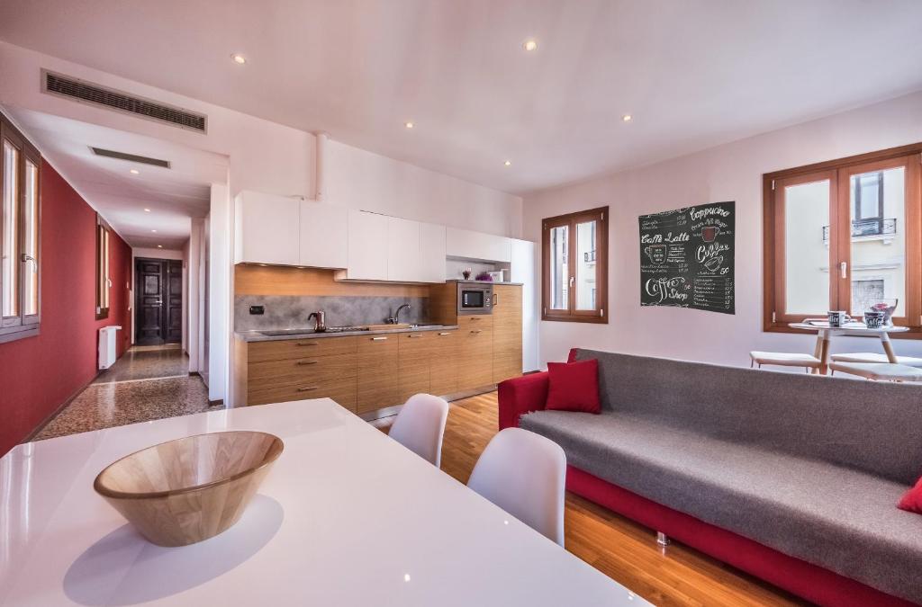 a kitchen and living room with a table and a couch at Ca' d'Oro suite in Venice