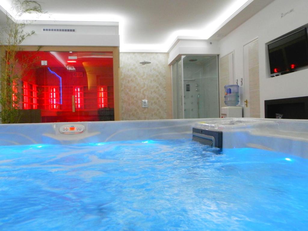 ハイドゥソボスローにあるKatalin Boutique & Wellness Apartmanokの- ホテルの客室内の青い水の大きなプール