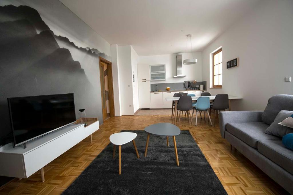 sala de estar con sofá y TV de pantalla plana en Krona Apartments, en Bovec