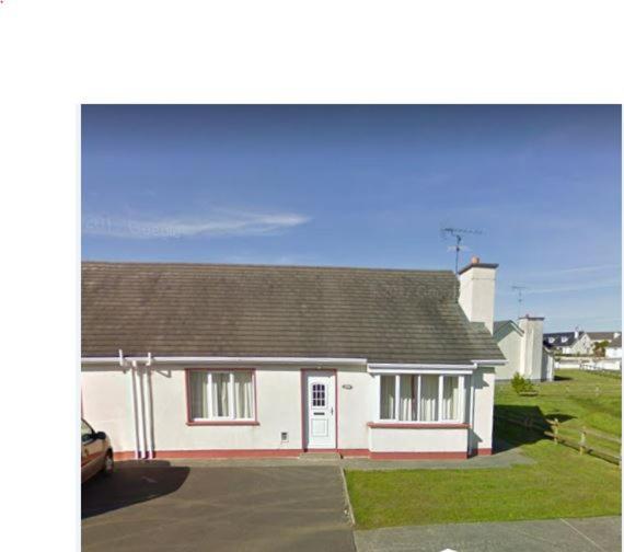 a white house with a car parked in front of it at 12A Benbulben View in Bundoran