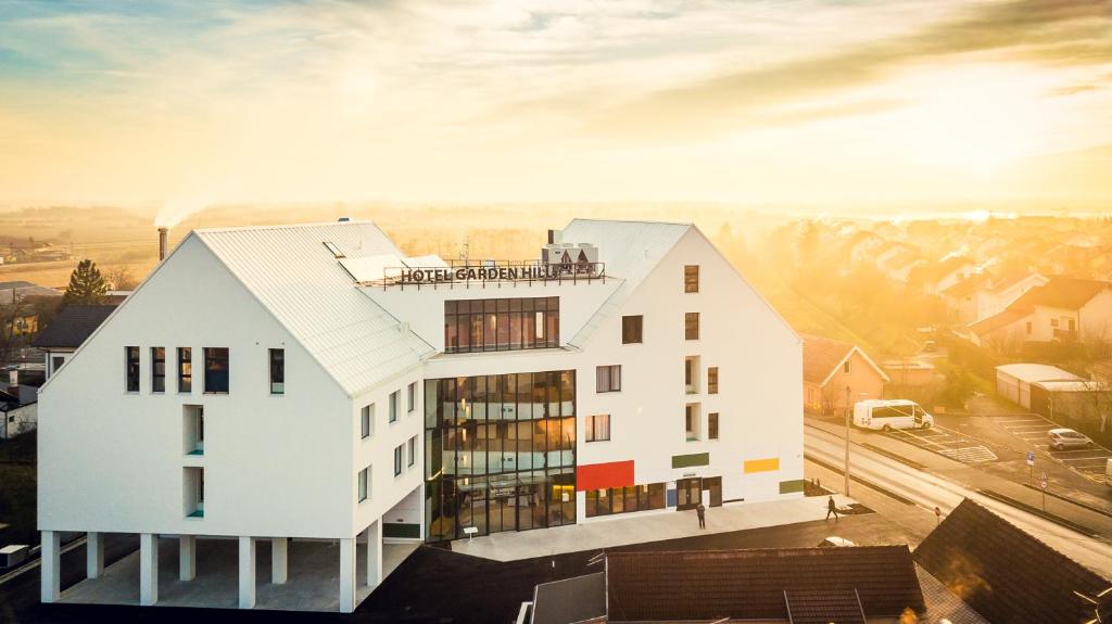 eine Darstellung eines Gebäudes mit der Sonne im Hintergrund in der Unterkunft Hotel Garden Hill in Velika Gorica